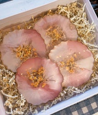 a box with four pink flowers in it